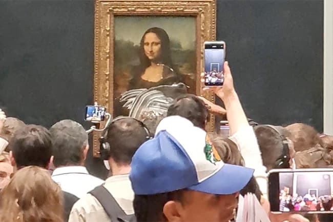 Man dressed as old woman throws cake at Mona Lisa painting