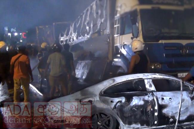 Speeding car crashes into parked truck and bursts into flames
